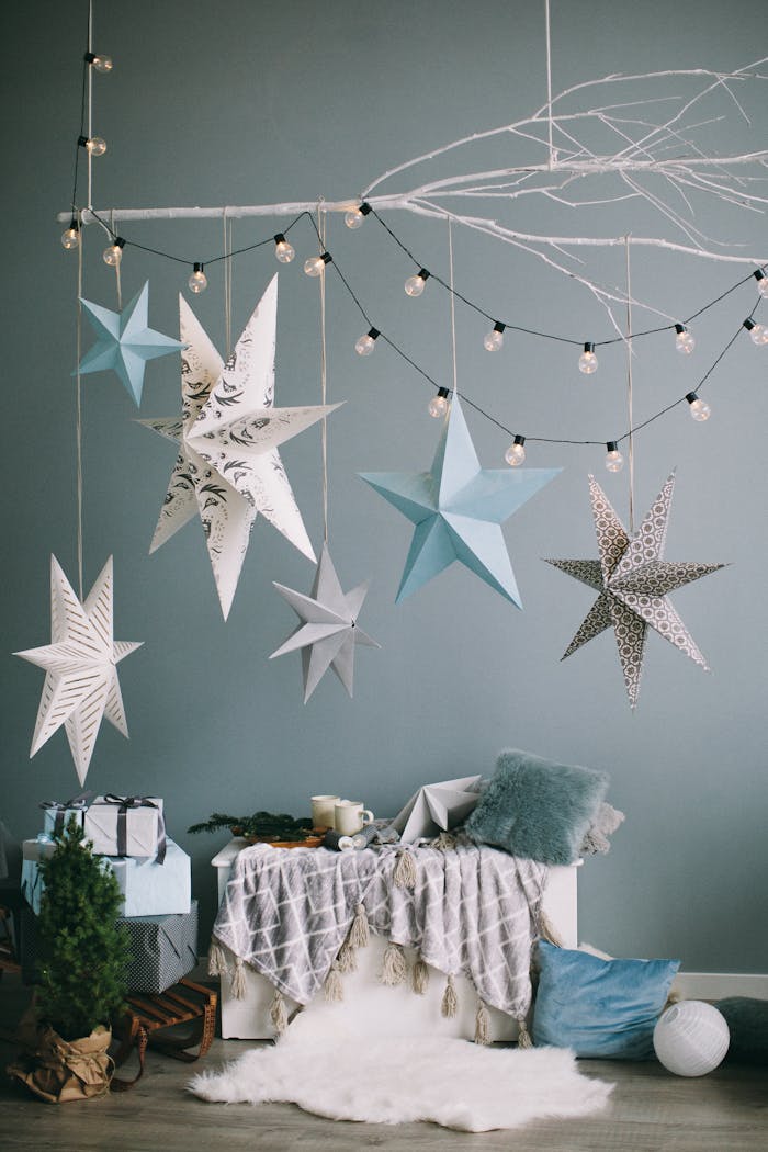 Hanging decorative stars with gifts and cozy decor for a festive indoor Christmas setting.